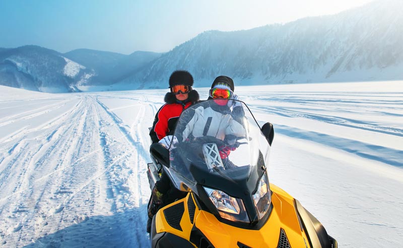 two people riding on a snowmobile