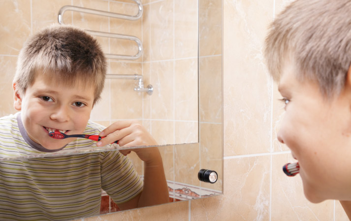 young boy brushing his teeth