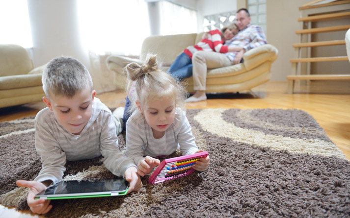 young boy and his sister playing on tablet