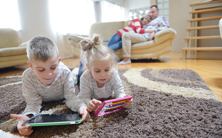 young boy and his sister playing on tablet