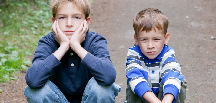 young boys sitting and waiting and acting very bored