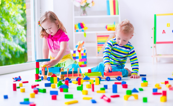 young children happily playing with their toys