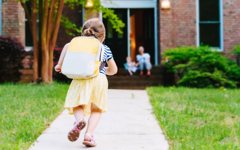 young girl coming home from school