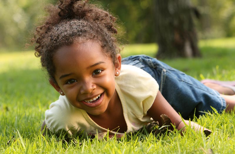 young girl on grass grinning