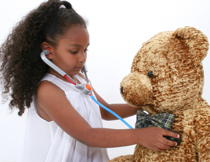 young girl playing doctor and listening to bears heart