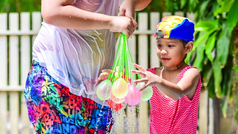 young girl playing with easy quick fill water balloons