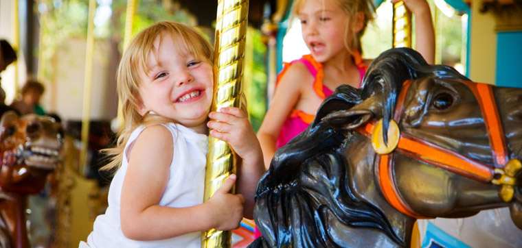 young girl riding carousel