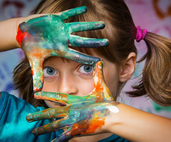 young girl with paint on hands